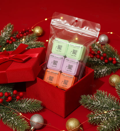 Packaged shower steamers with QR codes on a red background with Christmas decorations